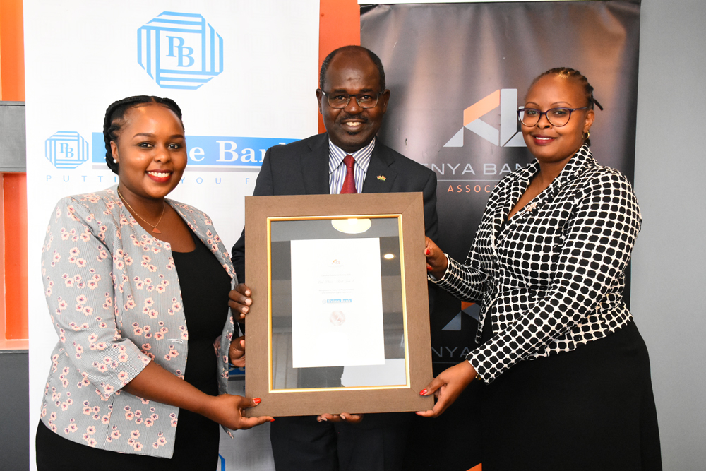 Kenya Bankers Association Chief Executive Mr. Habil Olaka presents the first runners-up award for Best Bank in Customer Responsiveness and Satisfactory Digital Experience in Tier II category to Prime Bank's Head of Customer Service Ms. rosemary Kiboro( right) and Head of Marketing Ms. Connie Kirika.